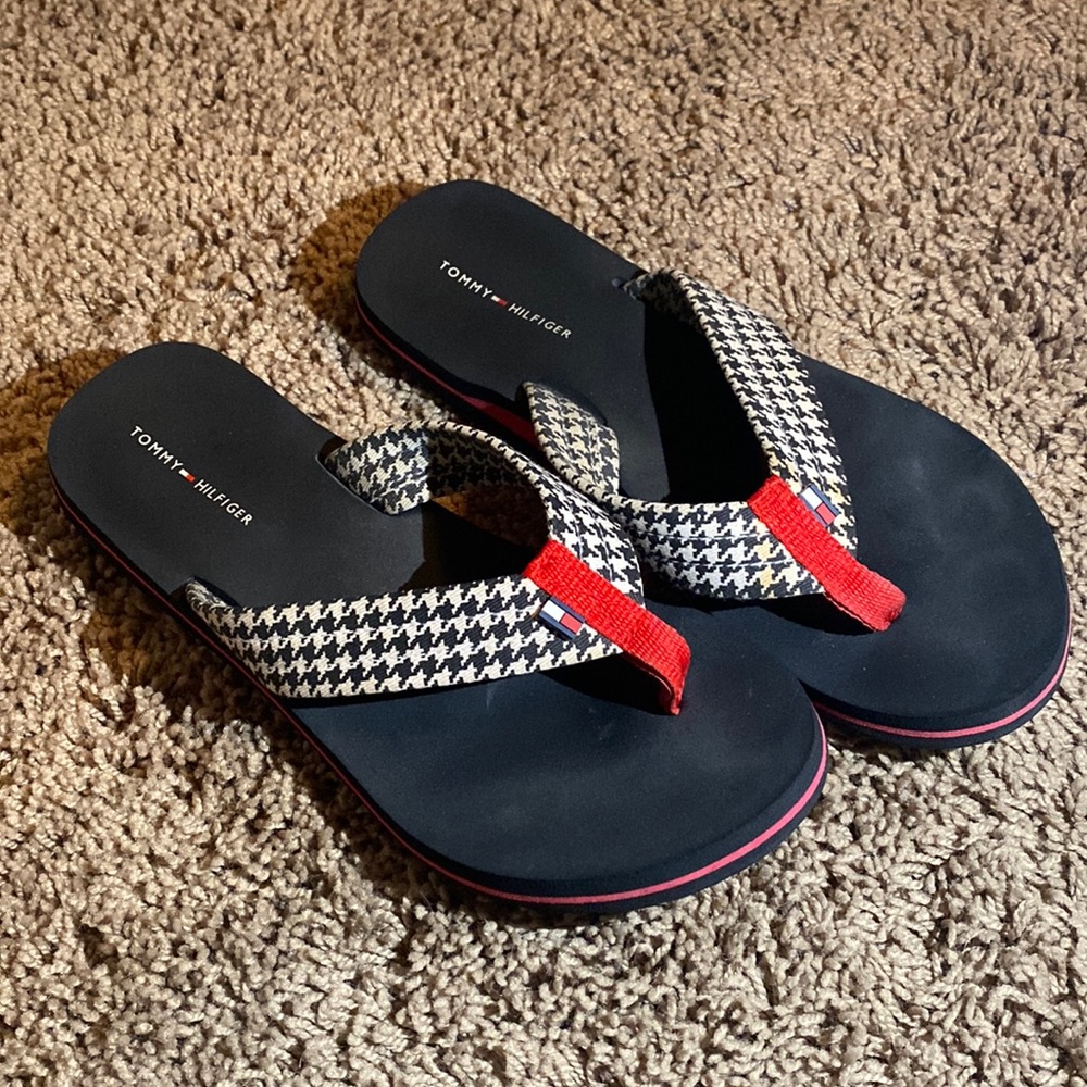 Navy blue, white, and red Tommy Hilfiger flip flops.